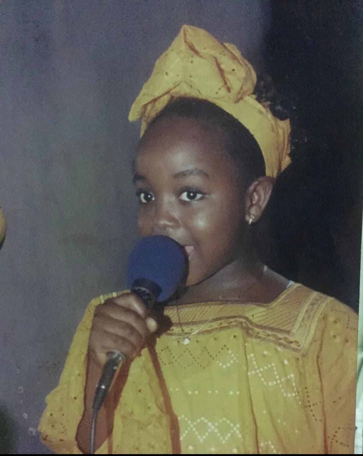 Jennifer as a young girl, speaking into a microphone